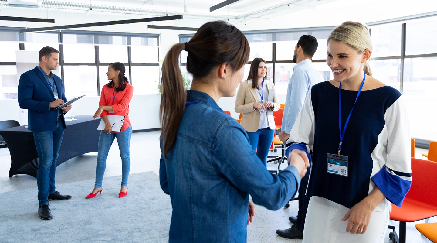 Business networking event with attendees introducing themselves and shaking hands